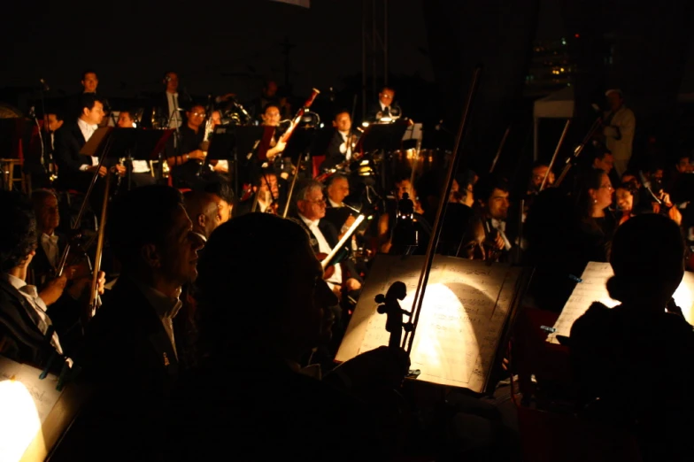an orchestra conductor conducting a band on a stage