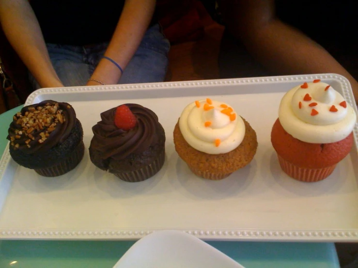 a row of different cupcakes sitting on a plate