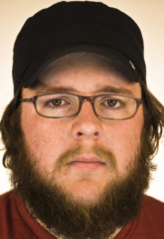 man with glasses and beard has a cap on his head