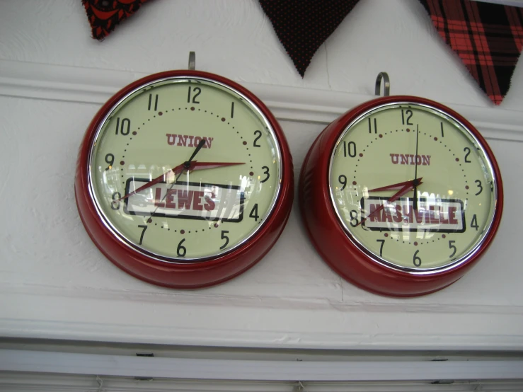 two red clocks showing different time zones