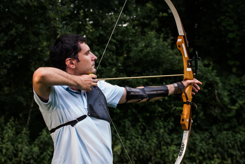 a man shooting a bow with a wooden stick