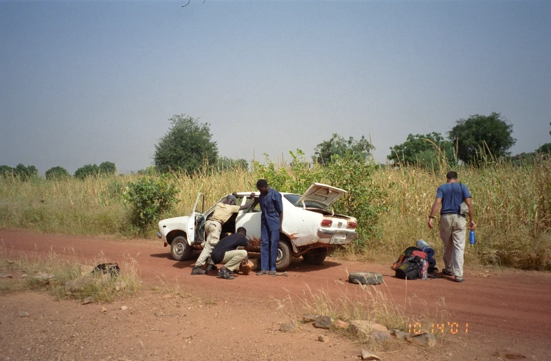 two people next to a car that has just been damaged