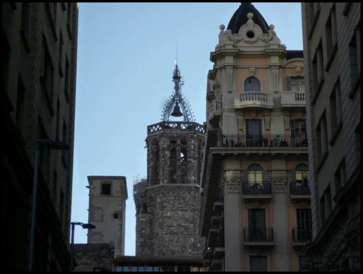 a tower with a clock in the middle next to other buildings