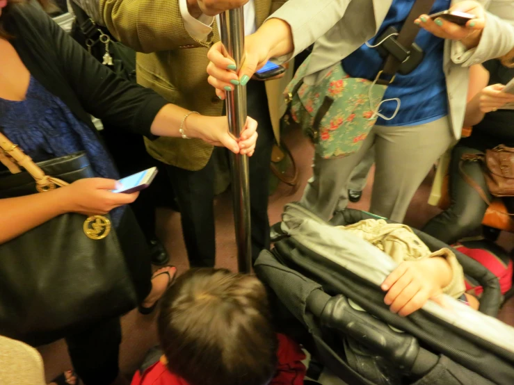 a group of people are gathered and looking at their phones