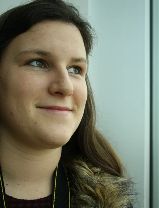 a woman wearing a black shirt and a large gold necklace