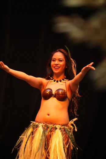 a woman dressed in a hula and costume performing