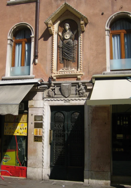 an old building with a store front and a statue