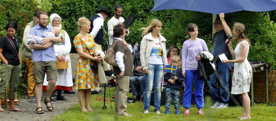 some people in a park with a blue umbrella