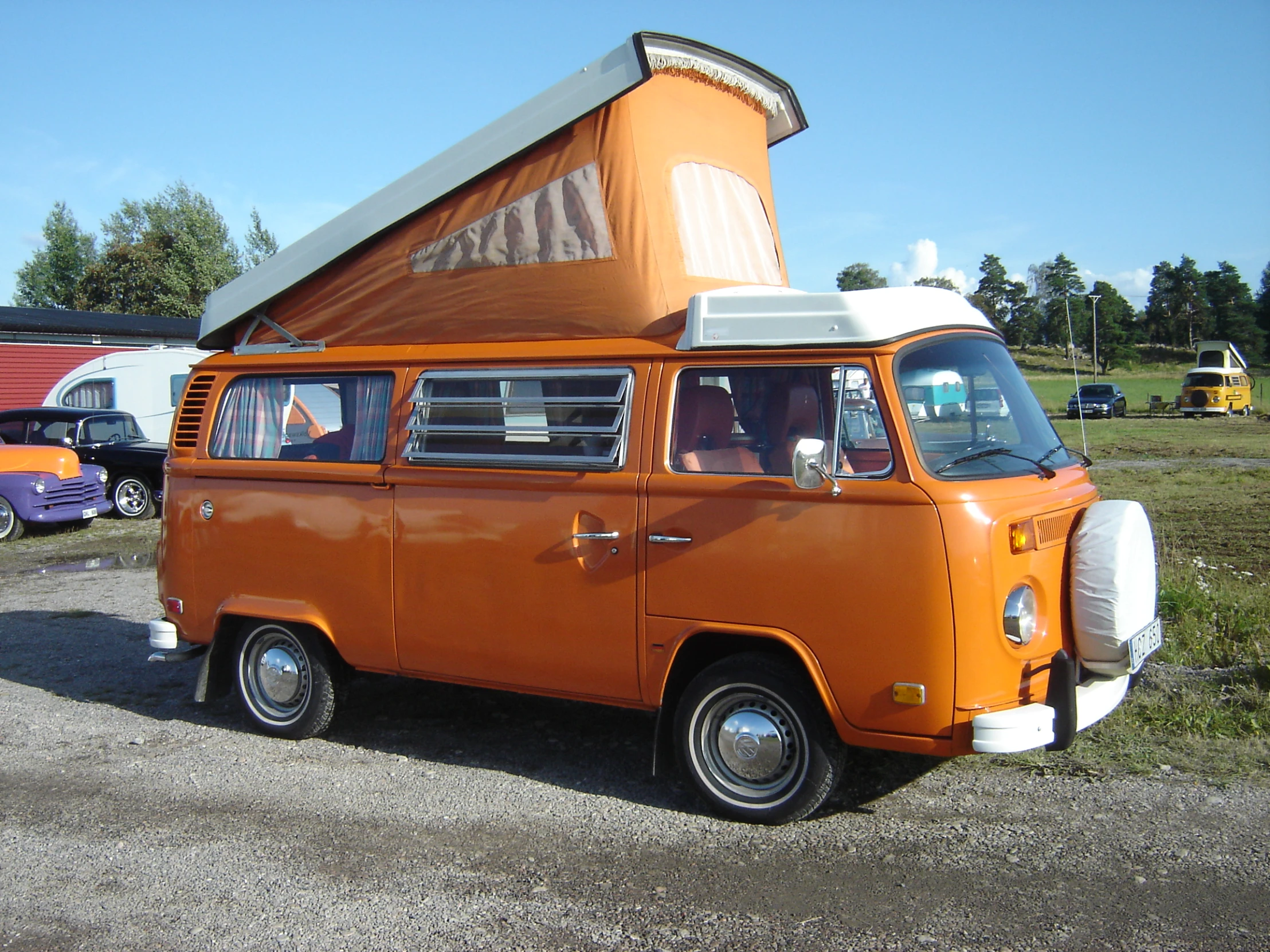 an orange van with a camper attached to it