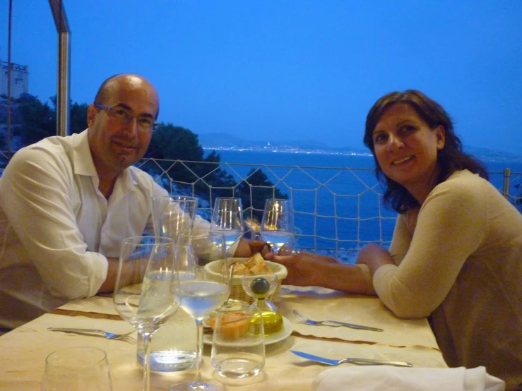 two people sitting at a table with wine glasses
