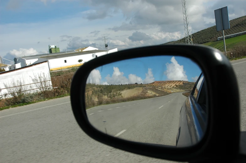 there is a side view mirror and some buildings on the street