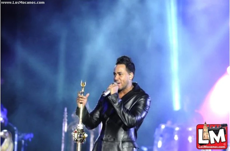 a man in black leather is holding an award