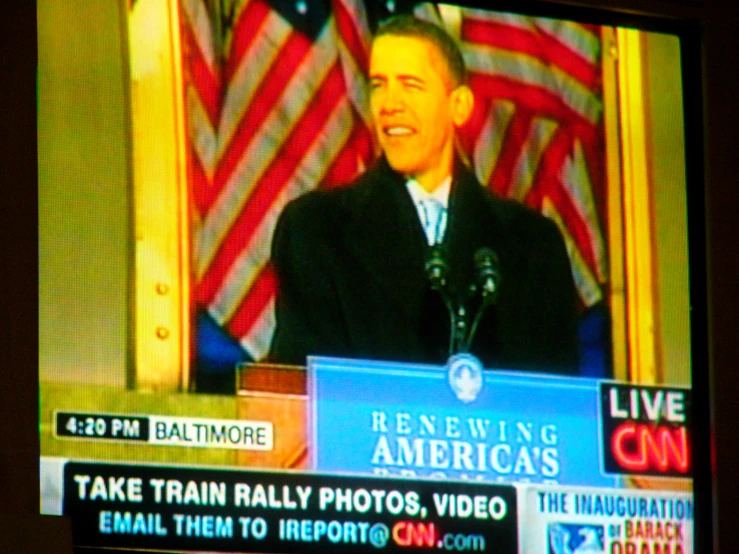the tv screen has the president giving a speech