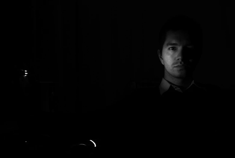 man in dark room with only light in the dark