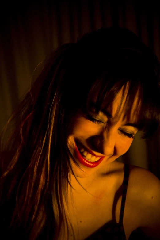 a smiling woman is showing her well - lit teeth