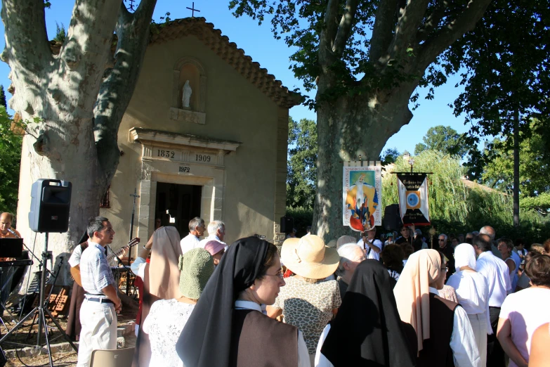 a large group of people gathered at a small church