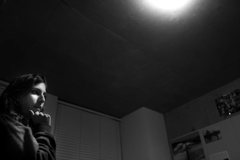 a woman brushing her teeth while standing in the dark