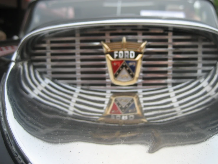 a po of a grille and emblem on an older car