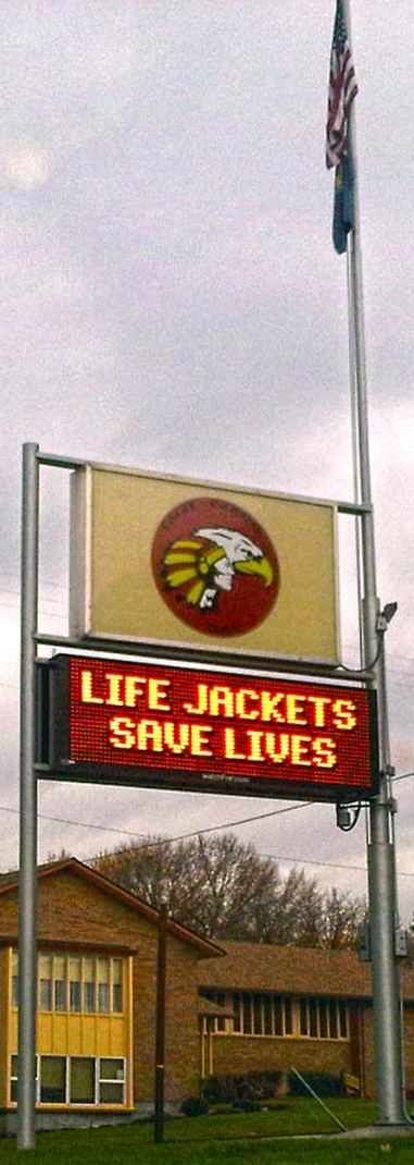 a sign at the football game stands by some buildings