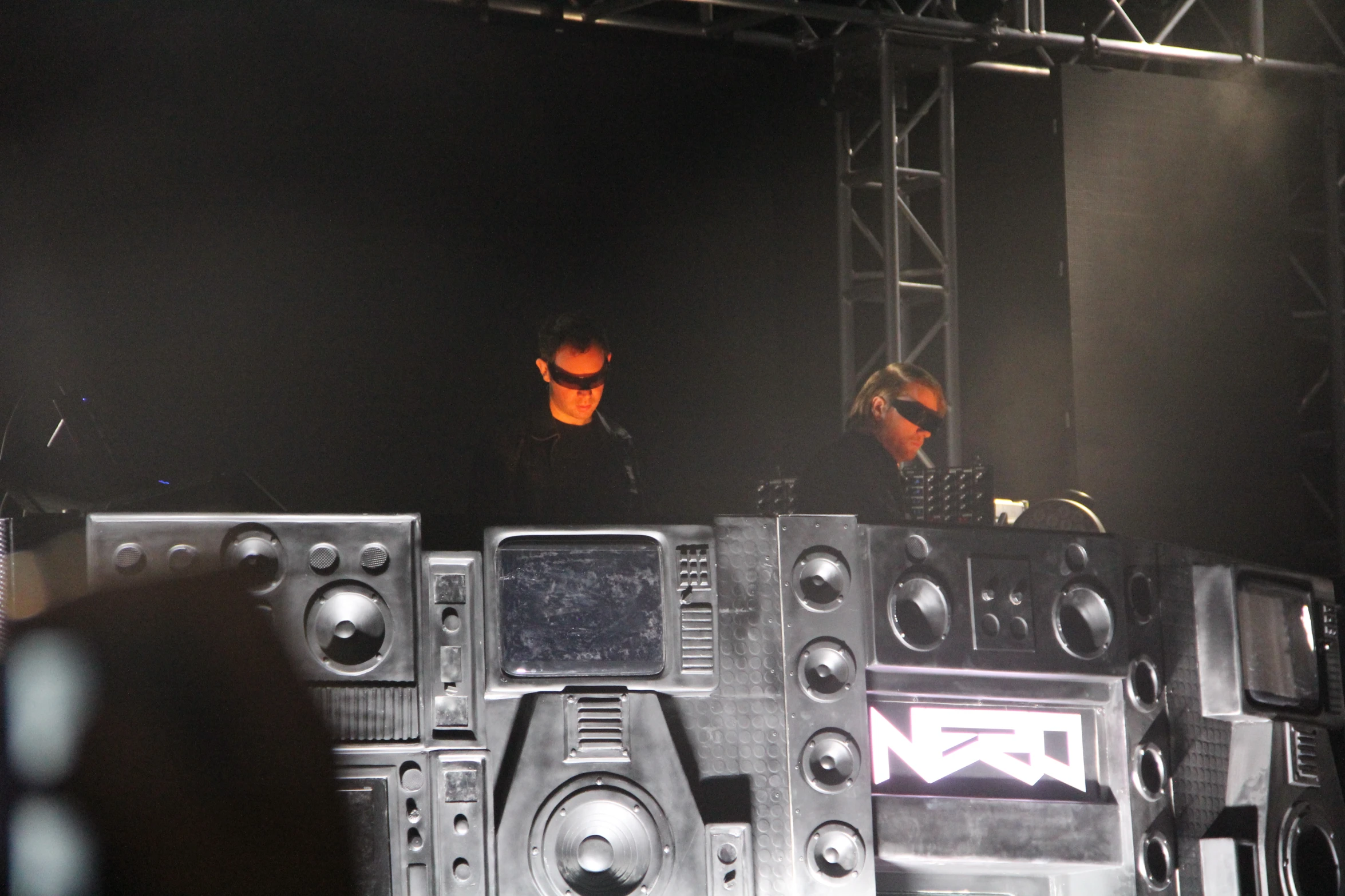 a couple of men standing on top of some speakers