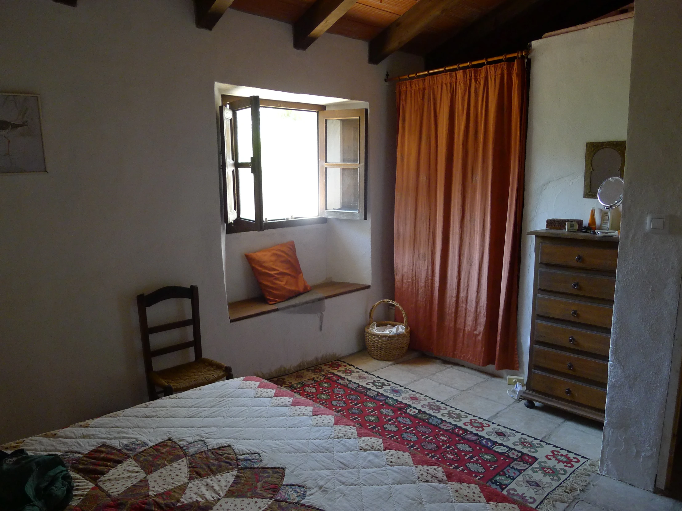 an image of a small bedroom with red curtains