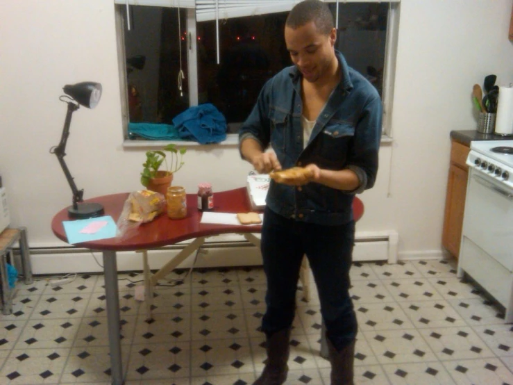 man stands in kitchen preparing a meal with meat