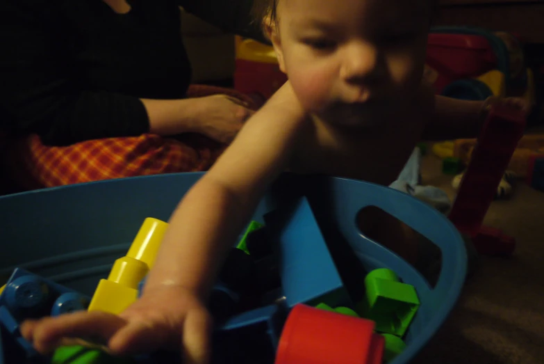 a small child playing with toys at the floor