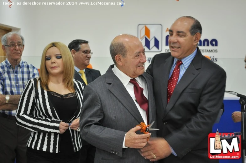 two men in suit and red tie posing for a picture