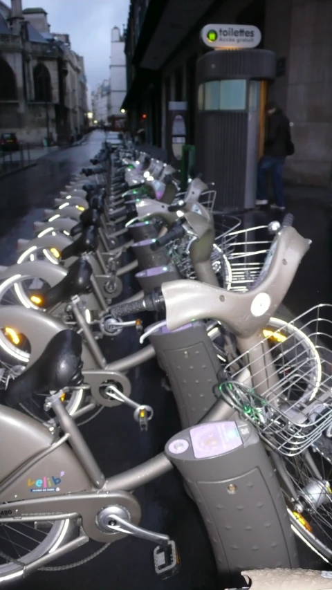 rows of parked bikes sit on the sidewalk