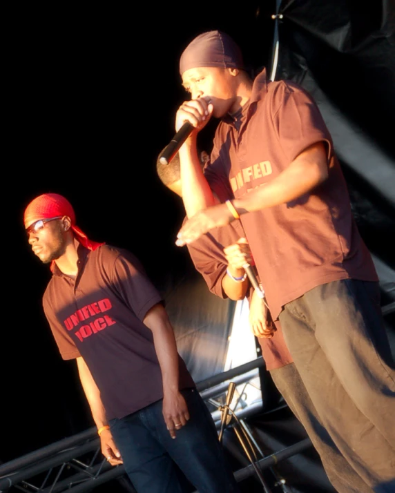 two young men are performing on stage