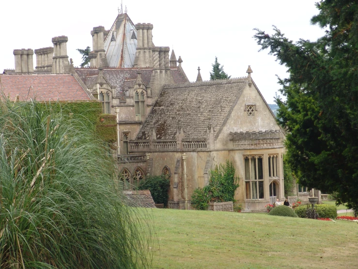 a very old looking house with a green field next to it