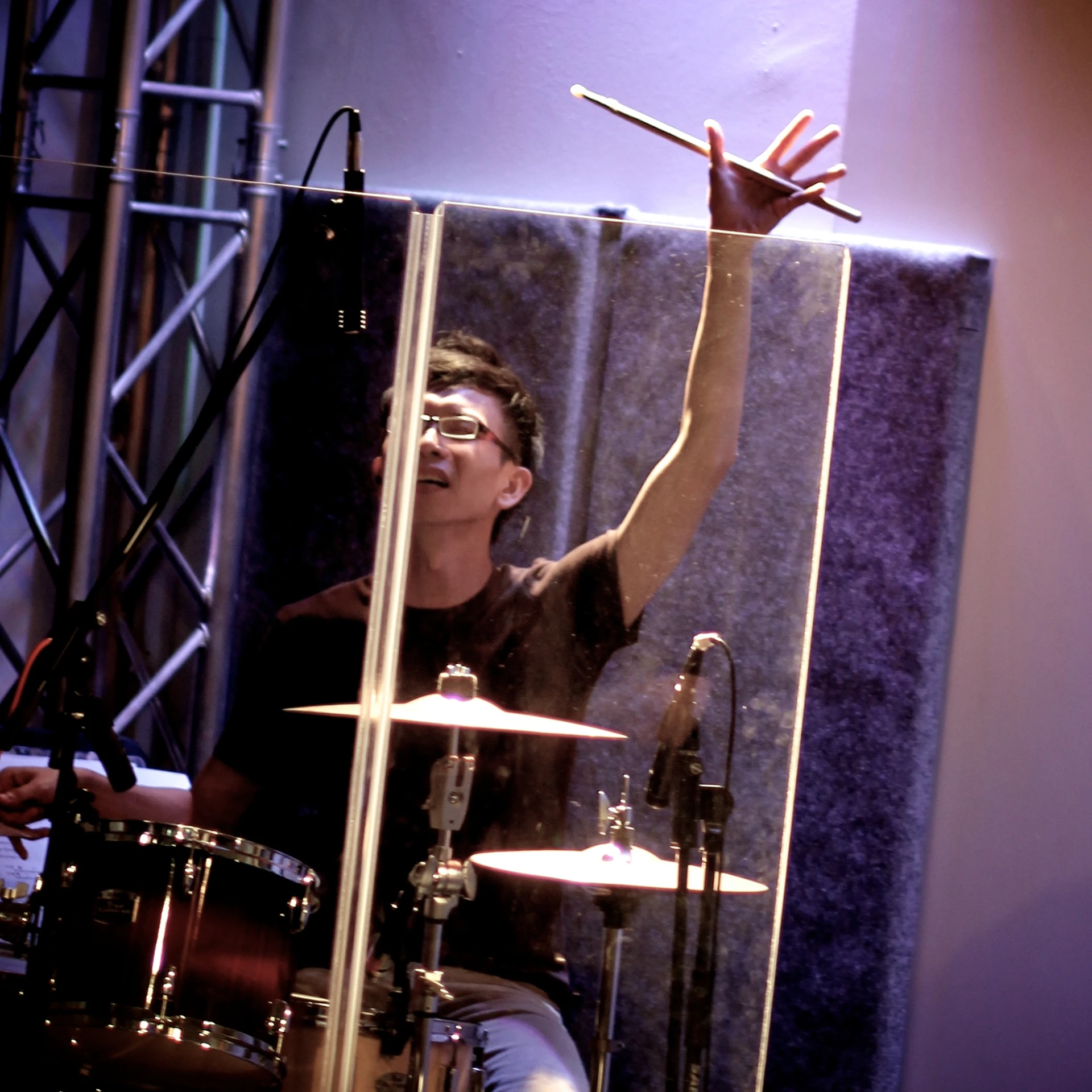 a young man with glasses playing the drums