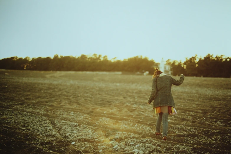 a woman standing in a field watching soing go by