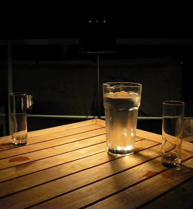 two glasses of water on top of a wooden table