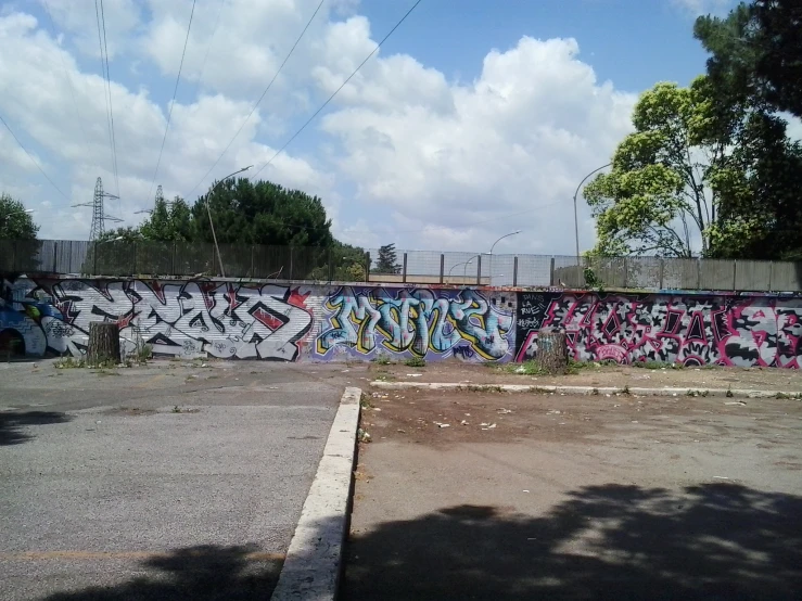 a parking lot with several colorful graffiti on the side