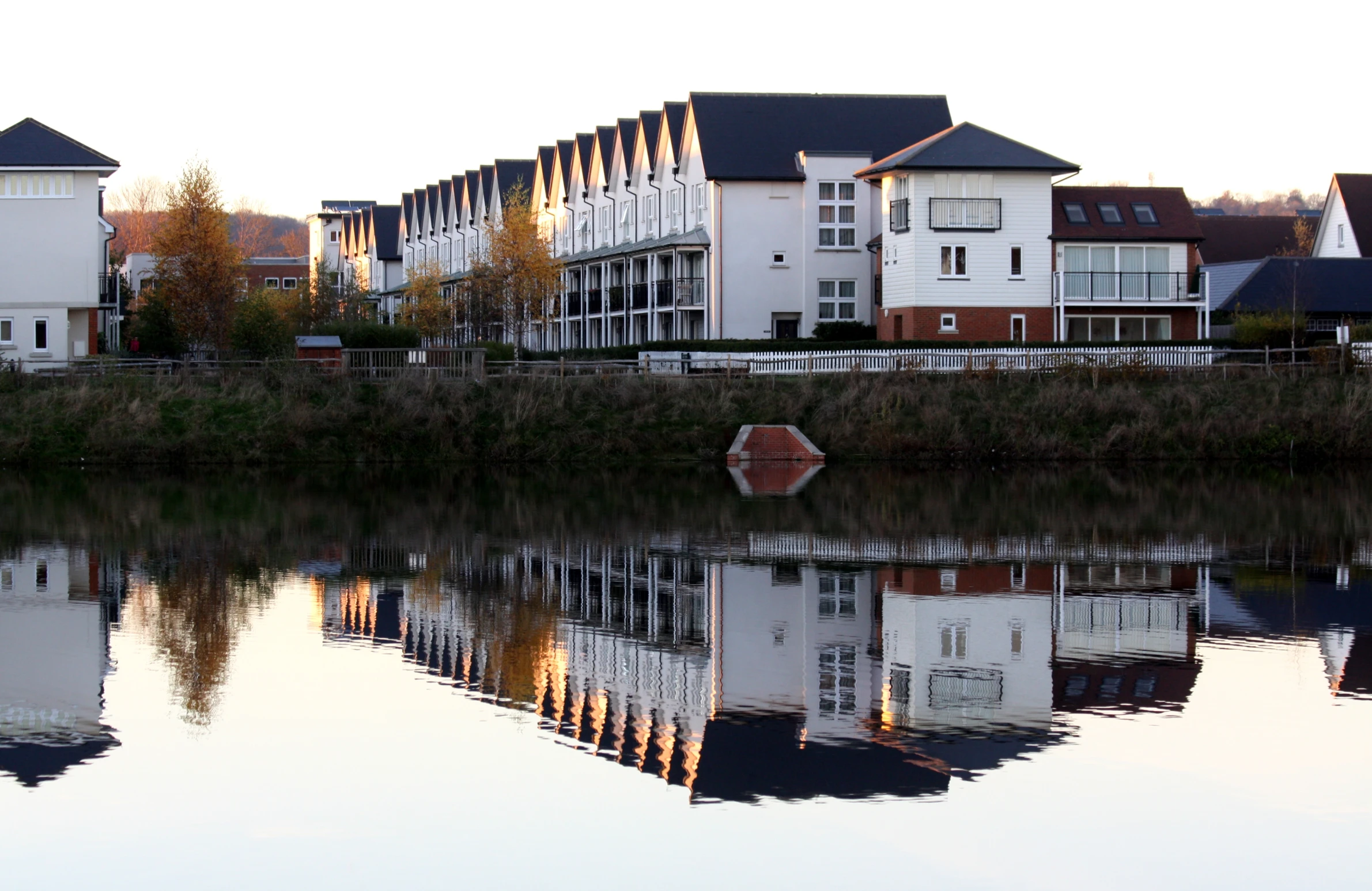 a row of buildings sit next to a river with water