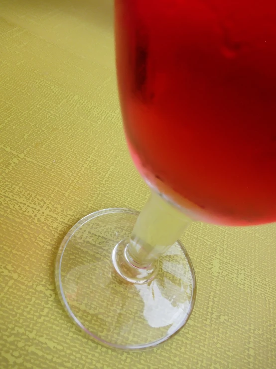 red liquid is being poured into a wine glass