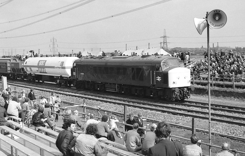 an old train with some people watching it