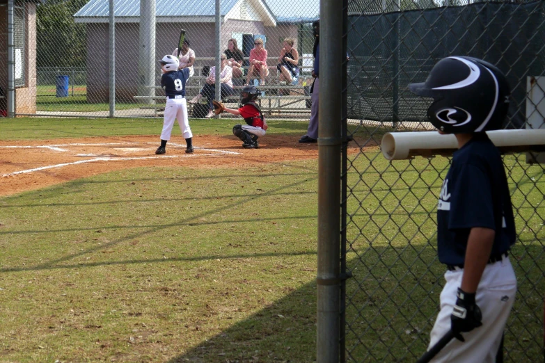 a  getting ready to bat during a little league game