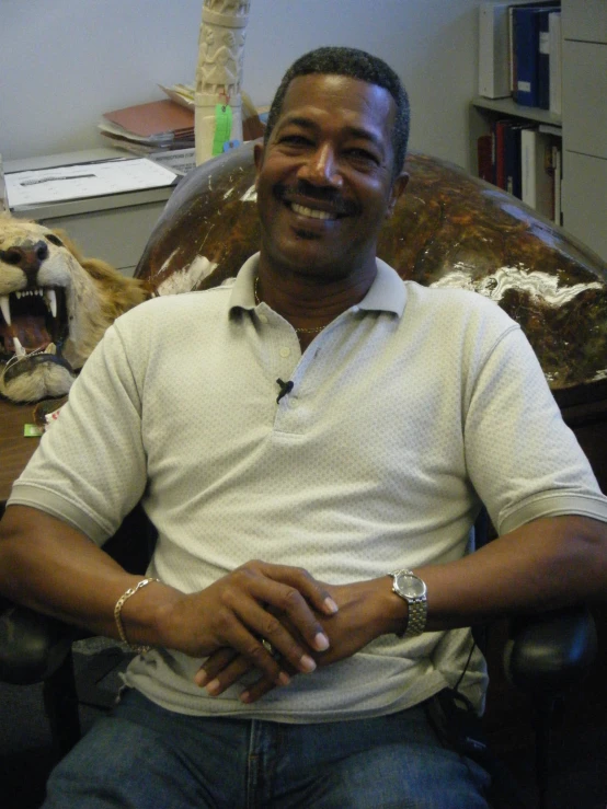 a man in a white shirt is sitting on a chair