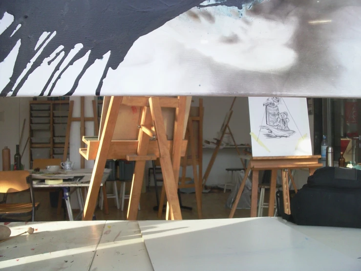 easels with drawing material and paint in a large studio