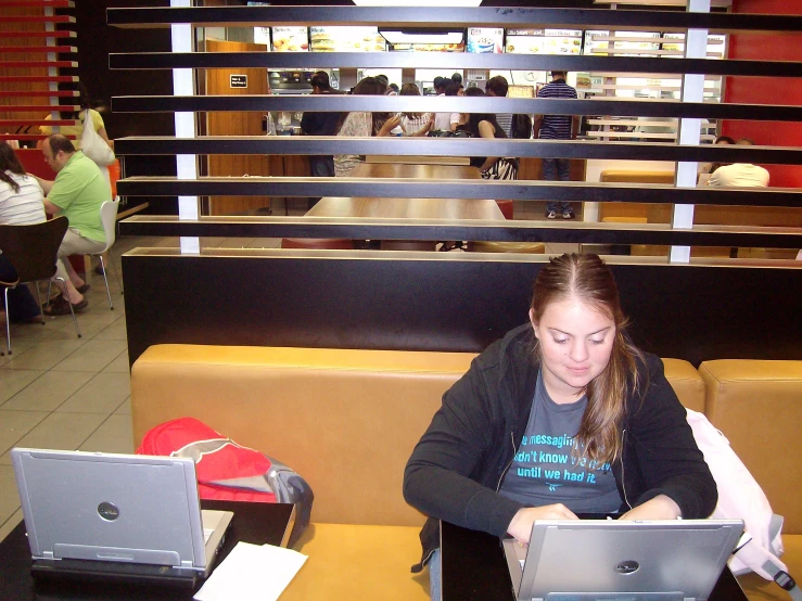 the woman uses her laptop at a table