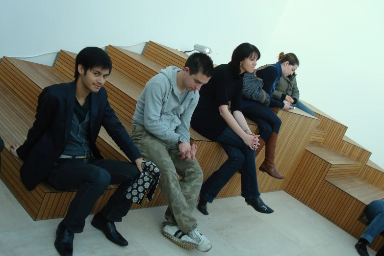 four young people sitting on stairs in a line