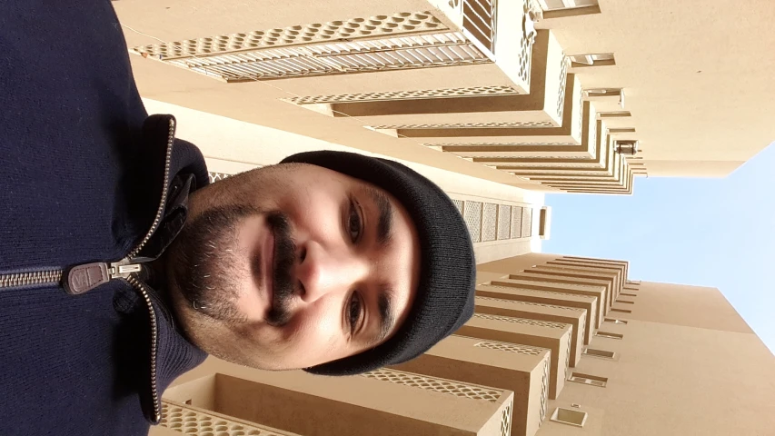 a man is standing in front of tall buildings