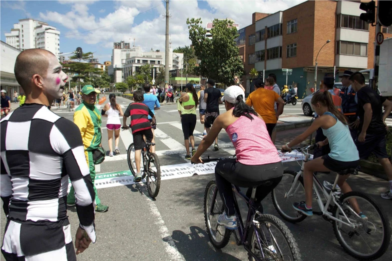 several people on bikes cross an intersection in a crosswalk