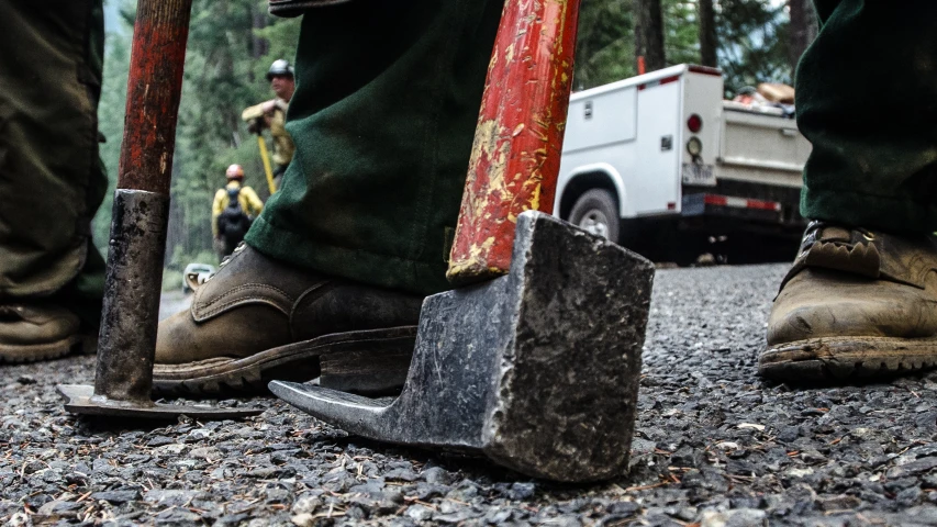 a person with hammers and a rock in the middle of a road