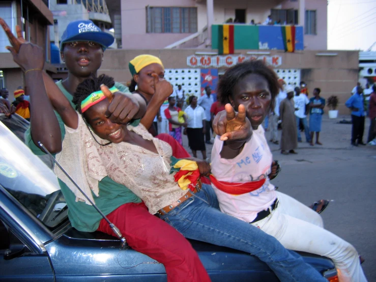 a couple of women that are sitting on the back of a car