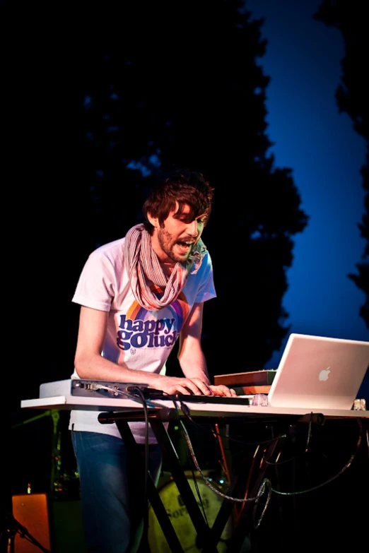 man with laptop in the dark on a bench