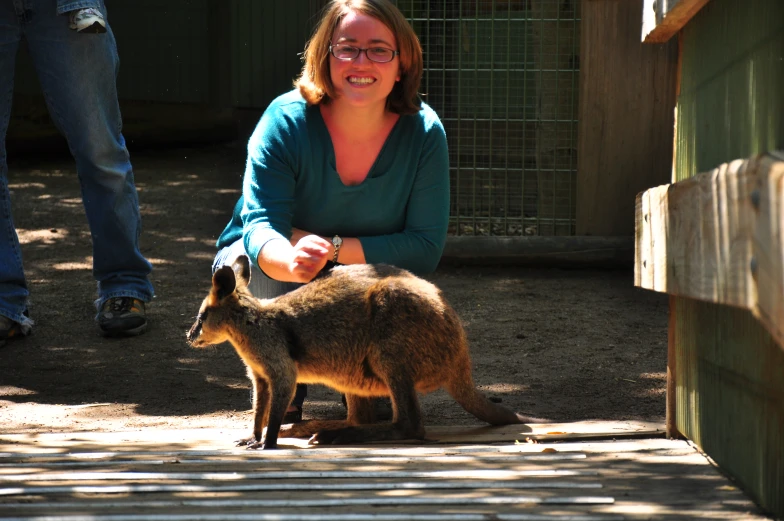a woman smiles with a kangaroo in front of her