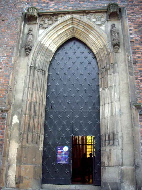 large ornate wooden doors on stone brick church